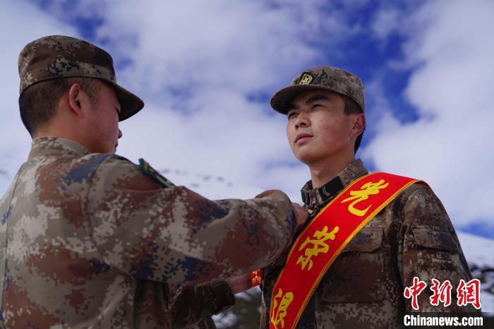 排長王朝偉(圖左)給退伍老兵佩戴大紅花。　西藏山南軍分區(qū)某團供圖