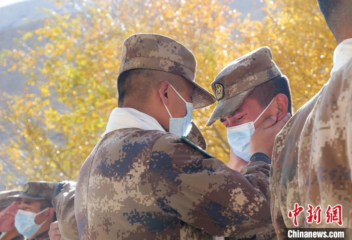 圖為什布奇邊防連退伍老兵與戰(zhàn)友相擁而泣，依依惜別。　徐昌成 攝