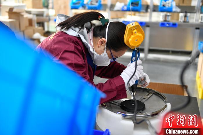 圖為工人正在組裝炊具?！∝暩聛硭?攝