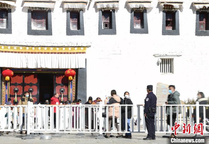 圖為1月23日，布達(dá)拉宮廣場(chǎng)派出所民警正在引導(dǎo)游客?！∝暩聛硭?攝