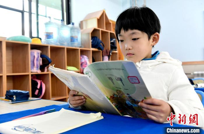 3月14日，西藏拉薩市第一小學(xué)一年級(jí)六班學(xué)生丁增樂吉在閱讀藏語課本。　李林 攝
