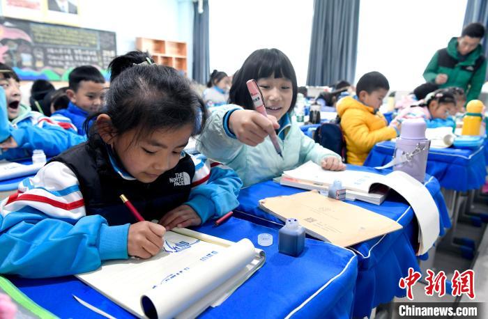 3月14日，西藏拉薩市第一小學(xué)一年級(jí)六班學(xué)生白瑪朗珍(圖左)在藏語文課上書寫藏文?！±盍?攝
