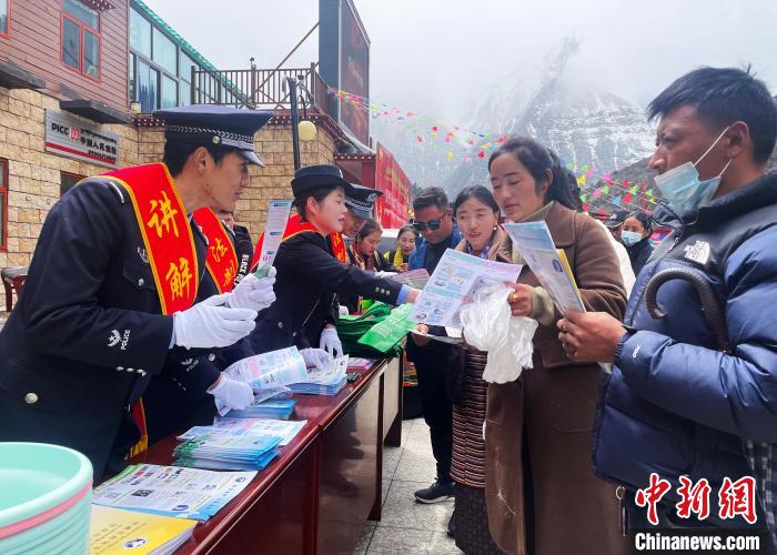 圖為山南玉麥邊境派出所民警為轄區(qū)群眾發(fā)放法律知識宣傳單。　鐘鑫 　攝