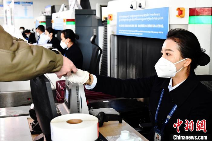 圖為機場工作人員為旅客辦理行李托運?！≈芎?攝