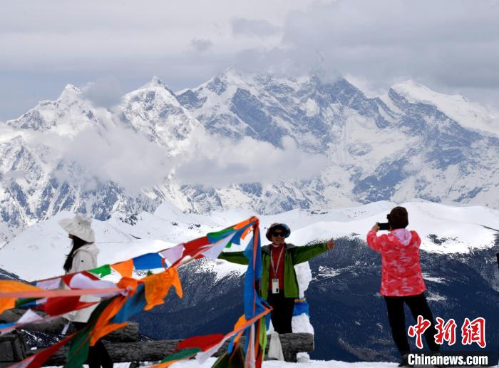 圖為5月14日，西藏林芝色季拉山觀景臺(tái)，游客與南迦巴瓦峰合影?！±盍?攝