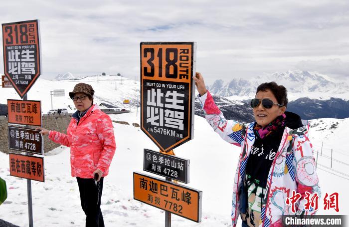 圖為5月14日，西藏林芝色季拉山觀景臺(tái)，游客與南迦巴瓦峰合影?！±盍?攝
