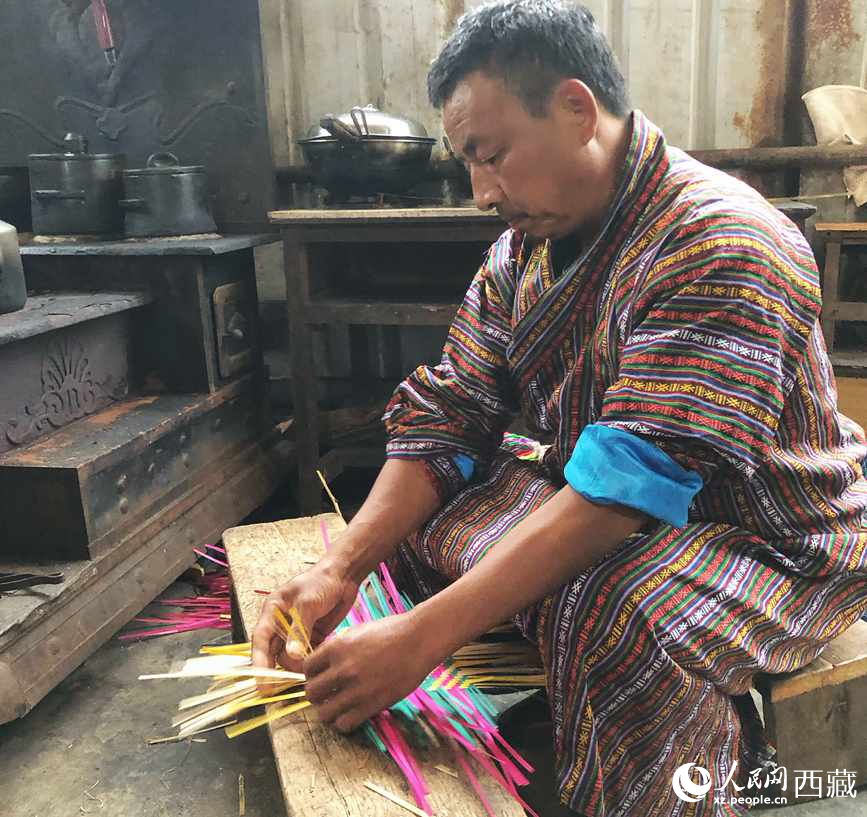 門巴族漢子愛(ài)明正在編織藤竹品。