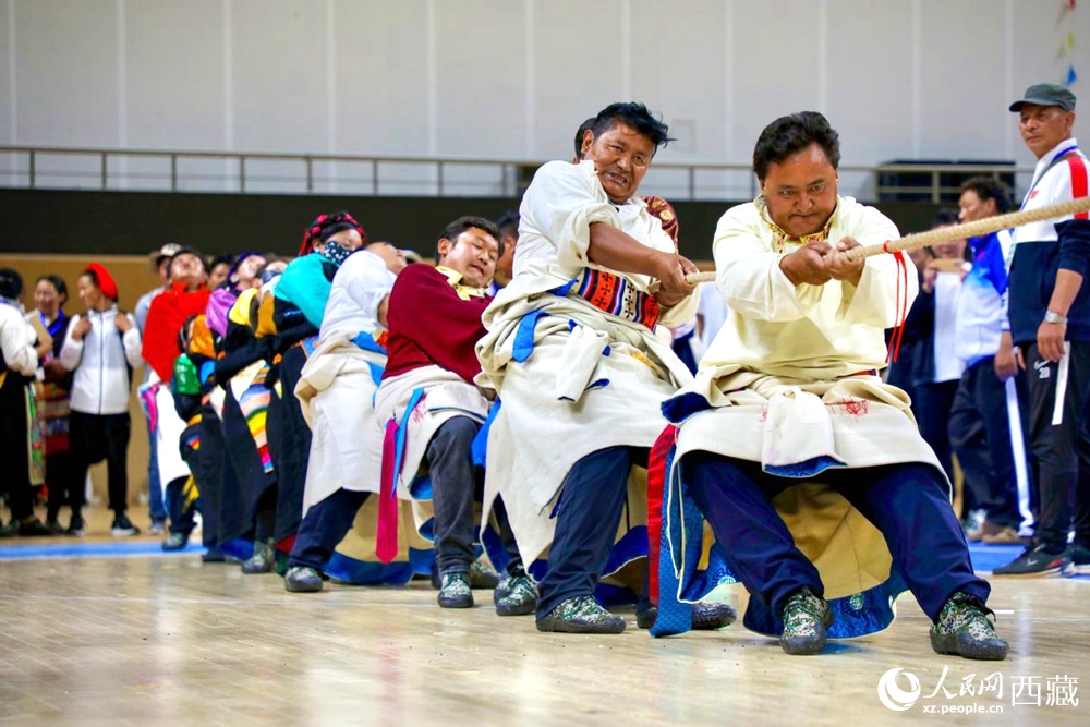 身著民族服裝的農(nóng)牧民選手在拔河比賽現(xiàn)場。
